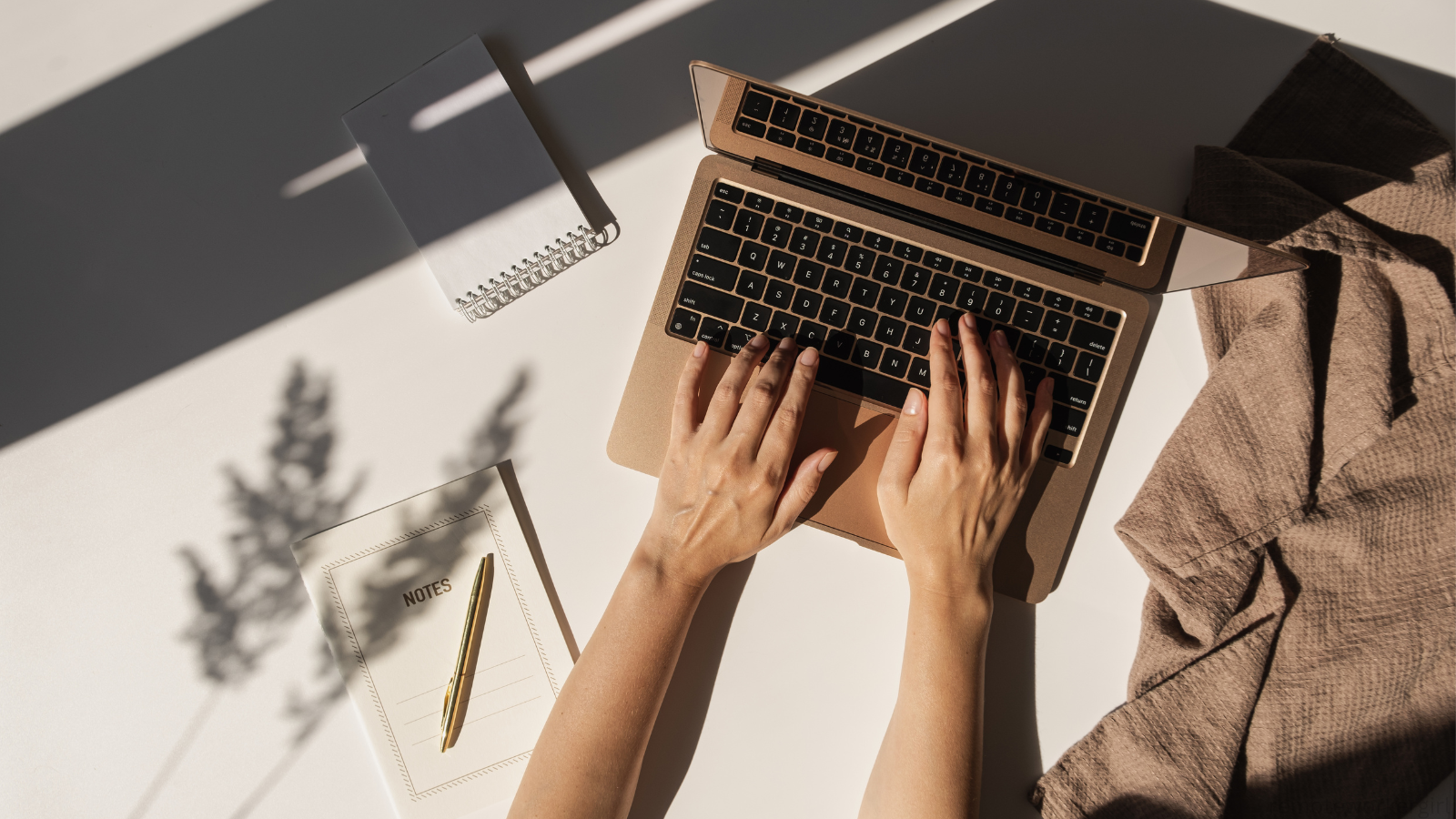 Hands typing on laptop